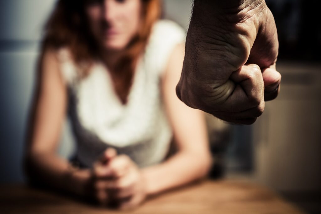 A blurred domestic abuse awareness image showing a raised fist in the foreground
