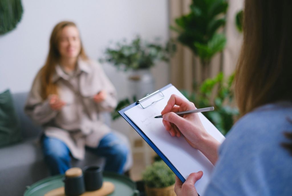 A support worker writing notes during a guidance session